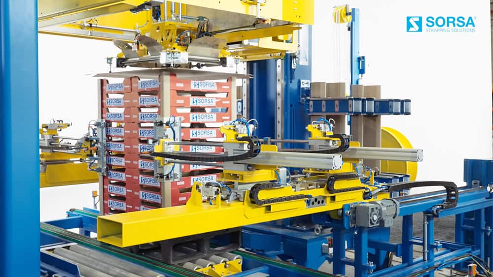 Sistema de flejado automático Sorsa integrado en línea de producción industrial.