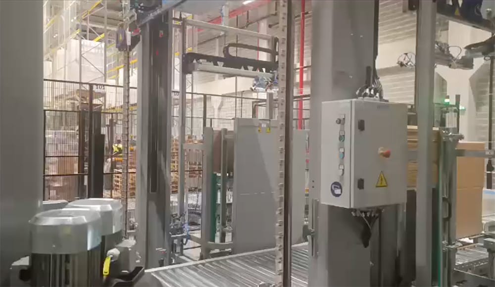 Sistema automático de colocación de cantoneras de papel de Sorsa integrado en una línea de flejado de palets.